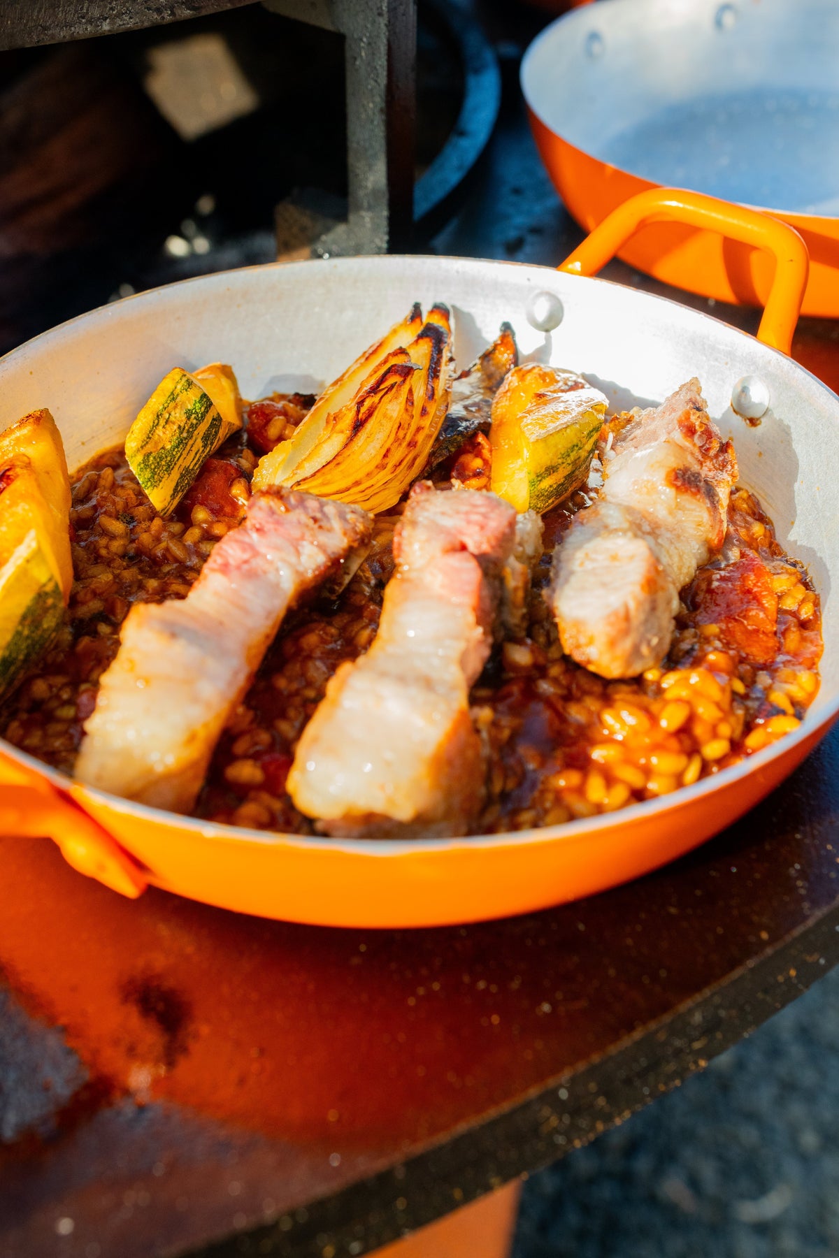 Arroz caldoso, legumes assados e bife de tira de porco dourado na chapa.